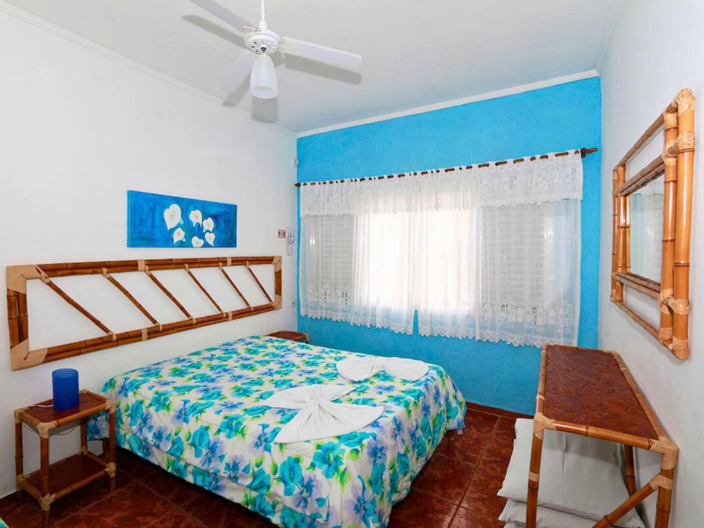 Suíte com parede azul e ventilador de teto